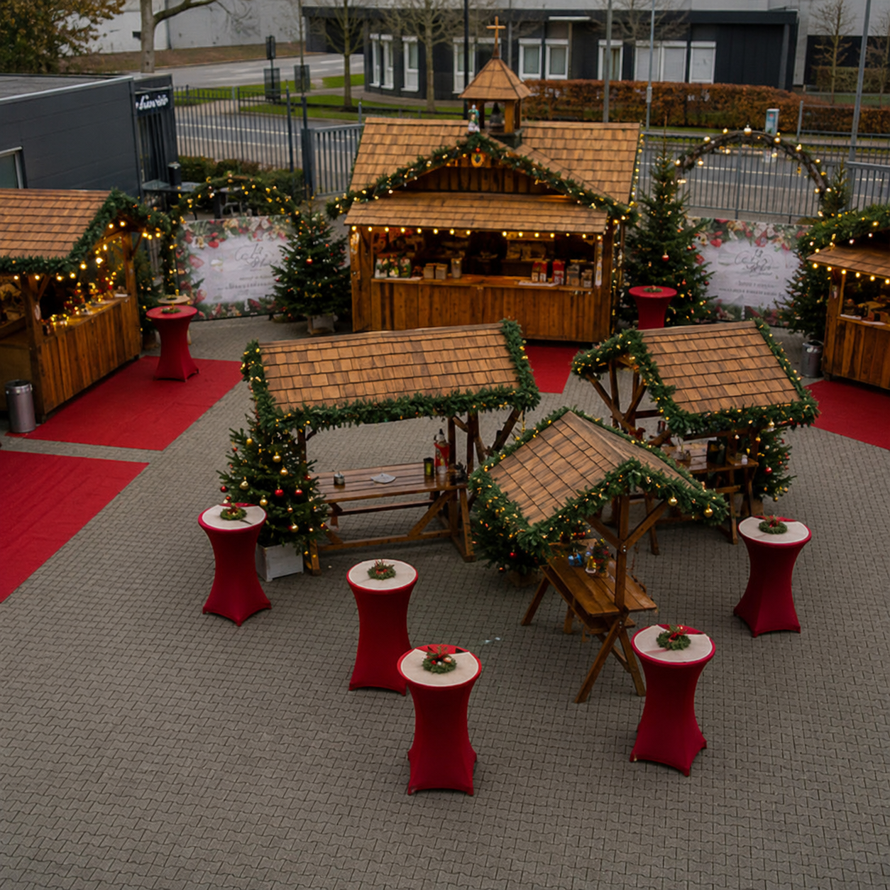 Kerstmarkt op locatie met verlichte kersthuisjes op een bedrijfsterrein